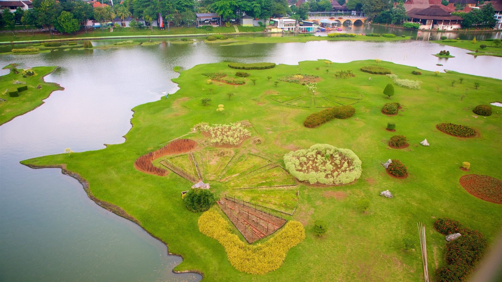 Pemandangan udara taman dan danau berbentuk peta Nusantara di Taman Mini Indonesia Indah, Jakarta Timur